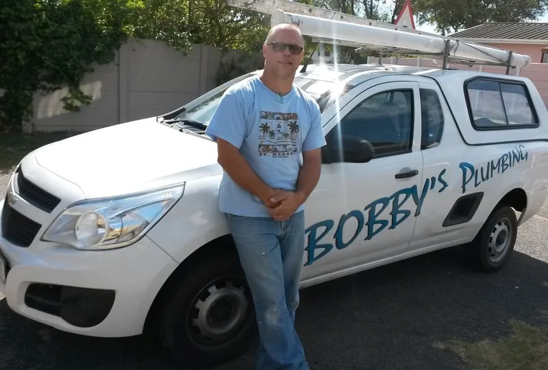 Robert “Bobby” Hutton beside his Bobby’s Plumbing vehicle