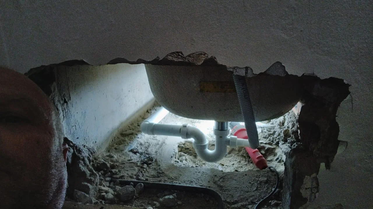Pipework exposed through a wall during a plumbing repair