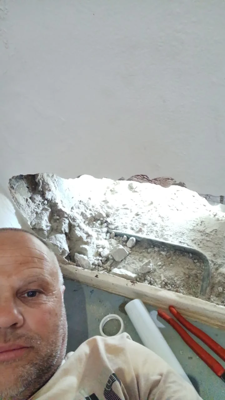 Bobby beside exposed pipework during a repair