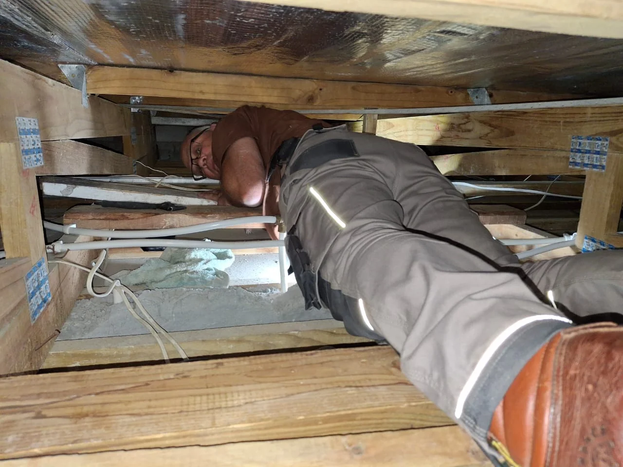 Bobby working on plumbing in a roof space