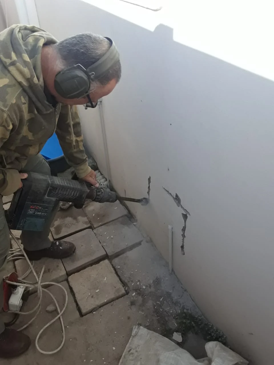 Bobby opening a wall to access plumbing