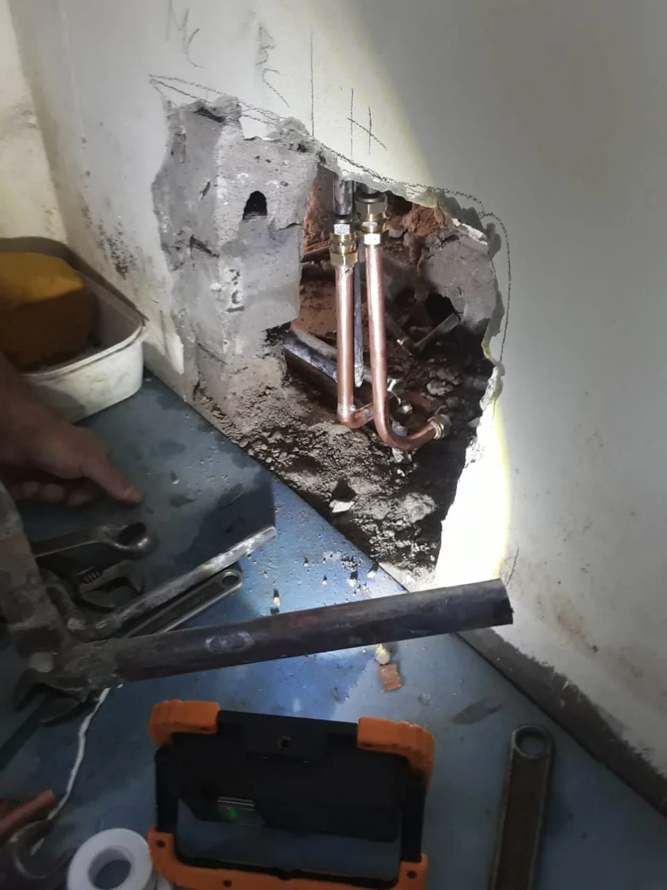 Copper pipework exposed inside a wall during a repair